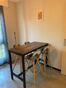 una mesa de madera con sillas en una habitación en STUDIO DIJON MARPAUX, en Dijon