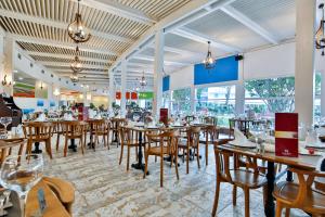 クズロットにあるCrystal Admiral Resort Suites & Spa - Ultimate All Inclusiveの木製のテーブルと椅子、窓のあるレストラン