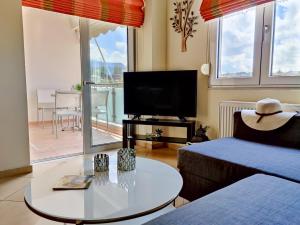 a living room with a bed and a table and a tv at Comfy Apartment in Platanes