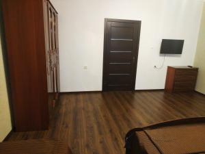 1 dormitorio con 1 cama, suelo de madera y puerta en Private House 9, en Beregovo