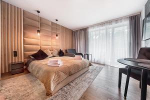 sypialnia z dużym łóżkiem i stołem w obiekcie Lividus Apart Park by Lev&Sons Apartments w Świnoujściu +32 zdjęcia