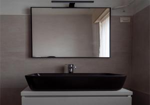 baño con lavabo negro y espejo en B&B Diana en Marostica