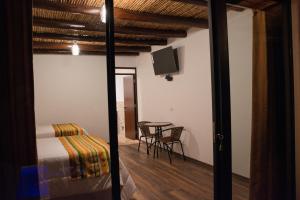 a room with a bed and a table with a television at Utcubamba River Lodge in Nuevo Tingo