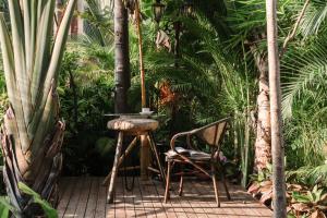 un patio con mesa y sillas en un jardín en Hidden Garden Inn (Airport Transfer), en Jinghong