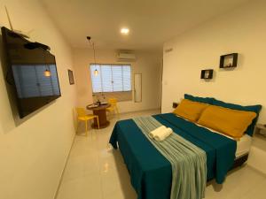una camera con letto blu e tavolo e sedie di Suite Sol - Residencial Vivas a Praia do Forte