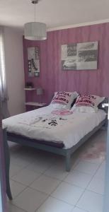 um quarto com uma cama com uma parede rosa em GITE LES MINOUX em Saint-Julien-de-Cassagnas