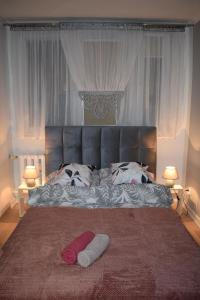 a bed with two white towels on it with two lamps at Apartament M-3 CENTRUM in Częstochowa