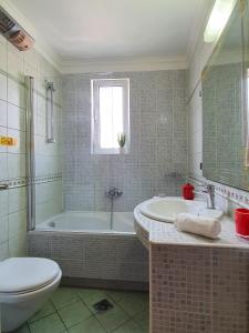 uma casa de banho com uma banheira, um WC e um lavatório. em Villa Smeralda em Saranda