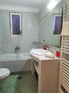 uma casa de banho com um lavatório, uma banheira e um WC. em Villa Smeralda em Saranda
