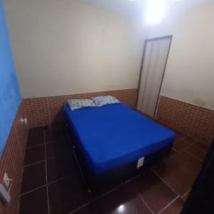 Cama azul en habitación con pared de ladrillo en Casa Dunas do Pero, en Cabo Frío