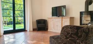 een woonkamer met een tv en een stoel bij Ferienhaus Hase in Burg