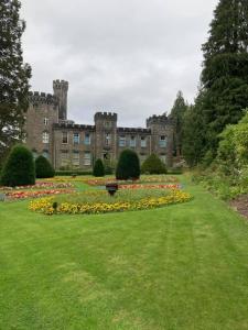 duży zamek z polem kwiatów przed nim w obiekcie Jrs place w mieście Merthyr Tydfil