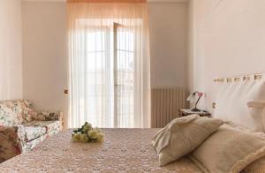 a bedroom with a bed and a window with flowers on it at Splendida e incantevole casa a due passi dal mare in Viareggio