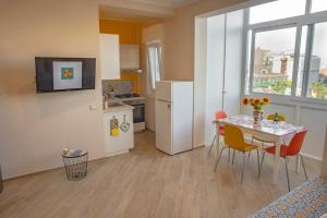 Ce petit appartement dispose d'une table, de chaises et d'une cuisine. dans l'établissement ARTrinacria Apartments - Qubba, à Palerme