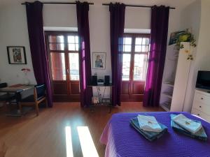 Habitación con cortinas moradas y cama con mesa púrpura. en Ole Málaga, en Málaga