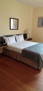 a large bed in a bedroom with a wooden floor at Rodmay Hotel in Powell River