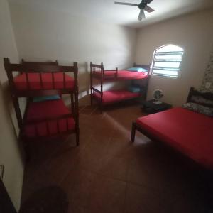 a room with two chairs and a bed and a fan at Casa Dunas do Pero II in Cabo Frio