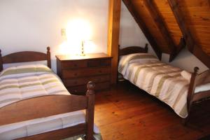 two beds in a room with wooden floors at Cabañas Los Maderos in Villa General Belgrano