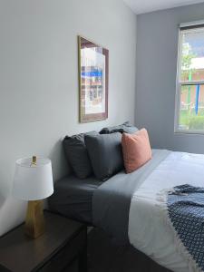 ein Schlafzimmer mit einem Bett und einem Tisch mit einer Lampe in der Unterkunft Sleepover 1BD 1BA Omaha Apartments in Omaha