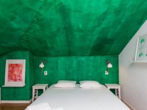 - une chambre avec un mur vert et un lit dans l'établissement SUPERNOVA - Hostel & Café, à Porto