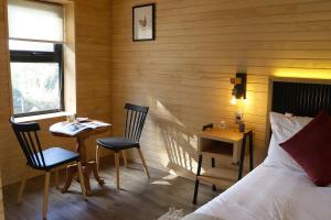 a bedroom with a bed and a table and a desk at Anoka Apart Hotel Boutique in Frutillar