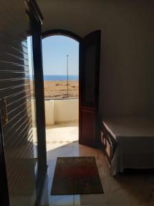 an open door to a room with a view of the beach at German Dolphin in Quseir