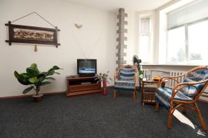 a living room with two chairs and a tv at Apart-Hotel Parasolka in Chernihiv