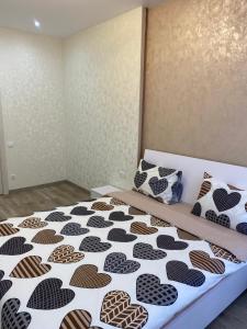 um quarto com uma cama com uma colcha preta e branca em Люкс апартаменти в ЖК Театральному.Центр міста em Rivne
