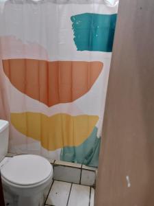 阿拉胡埃拉的住宿－Departamentos Patricia，浴室设有卫生间和色彩缤纷的浴帘