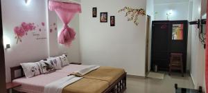 a bedroom with a bed in a room with flowers on the wall at Periyar Inn in Thekkady