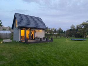 una pequeña casa con terraza en un campo en Skrundas namiņš en Skrunda