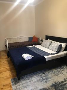 a bedroom with a large bed with blue sheets and pillows at my house in Tbilisi City