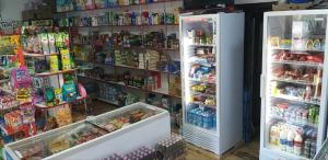 two refrigerators in a store with food and drinks at Guest House 777 in Türkistan