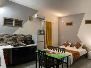 a small kitchen with a bed and a table in a room at Studio Résidence Beauregard in Koungou