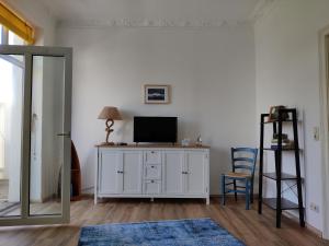 a living room with a tv and a white cabinet at Crampas 1 in Sassnitz