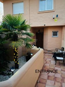 a palm tree in front of a building at Marbella Deluxe Rooms in Royal Cabopino Townhouse in Marbella