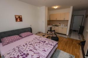 een kleine slaapkamer met een bed en een keuken bij Elite One Premium Apartment in Sarajevo