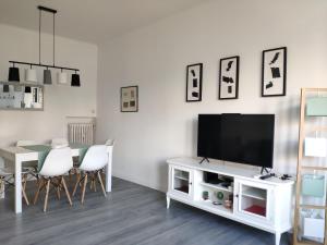 a living room with a television on a white cabinet at Casa Giustiniano - Metro San Paolo in Rome