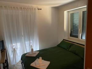 a bedroom with a green bed and a window at B&B La Fontana in Mirabello Sannitico