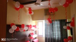 un montón de globos rojos y blancos colgando del techo en Samrat Hotel en Ludhiana