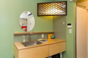 un baño con lavabo y espejo en 葡萄の長屋, en Tokio 53 fotos más