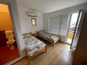 Habitación con 2 camas, aseo y ventana en Orange House, en Sozopol