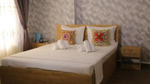 a bedroom with a large bed with white sheets and pillows at Samarkand Сity Guest House in Samarkand