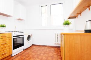 a white kitchen with a stove and a microwave at Blue River - Bacciarellego in Wrocław