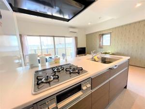 a kitchen with a stove top oven next to a sink at A.T. Hotel Hakata in Fukuoka