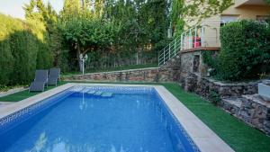 una piscina in un cortile con sedie e una casa di Casa Altavista en Ruidera a Ruidera