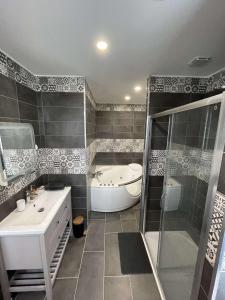 y baño con bañera, ducha y lavamanos. en Domaine d'Aveluy en Aveluy