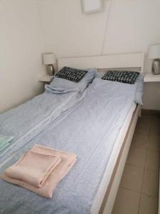 2 camas individuales en una habitación con toallas. en Plum13 en Szolnok