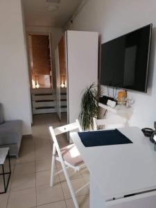 a living room with a white table and a tv at Plum13 in Szolnok