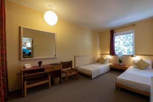 a hotel room with two beds and a mirror at Creta Solaris Holiday Apartments in Stalís